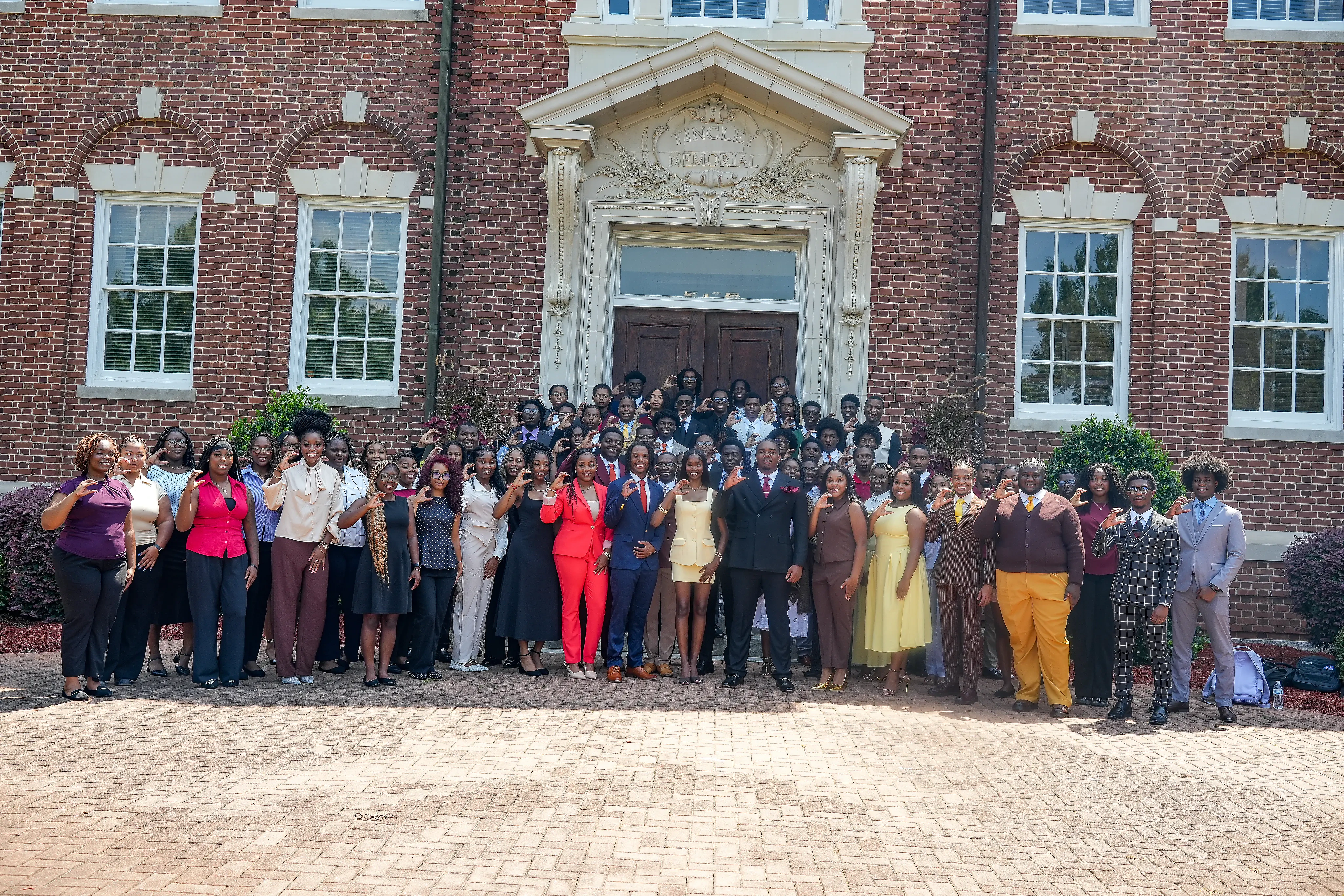Claflin University students gathered in front of Tingley Memorial Hall, many making the Claflin C hand sign