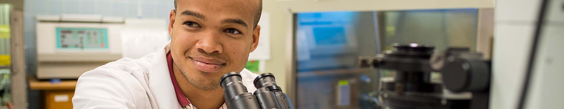 Claflin student looking through a microscope