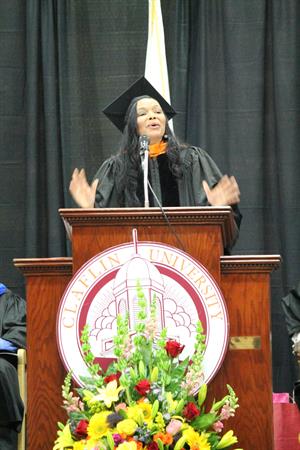 Margarita Anderson Speaking at Podium in Cap and Gown