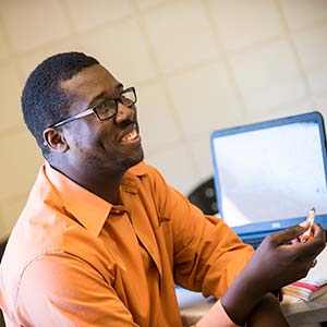 Student smiling and talking in a classroom