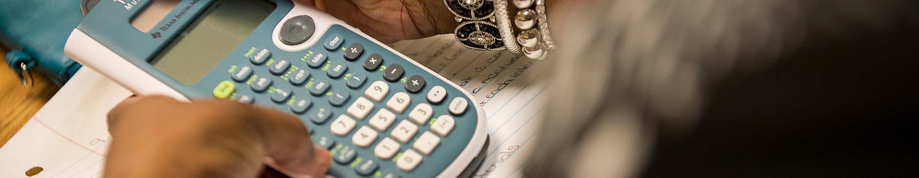 Student in classroom using a calculator